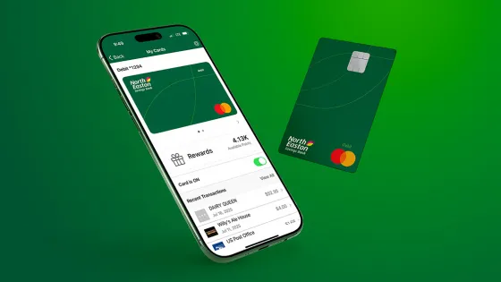 A phone with the North Easton Savings Bank mobile app displaying a North Easton Savings Bank personal debit card, purchase history, and purchase rewards and physical North Easton Savings Bank personal debit card next to the phone with a gradient background.