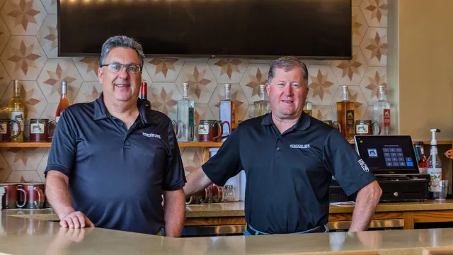North Easton Savings Bank local business partners sitting and smiling behind a bar counter